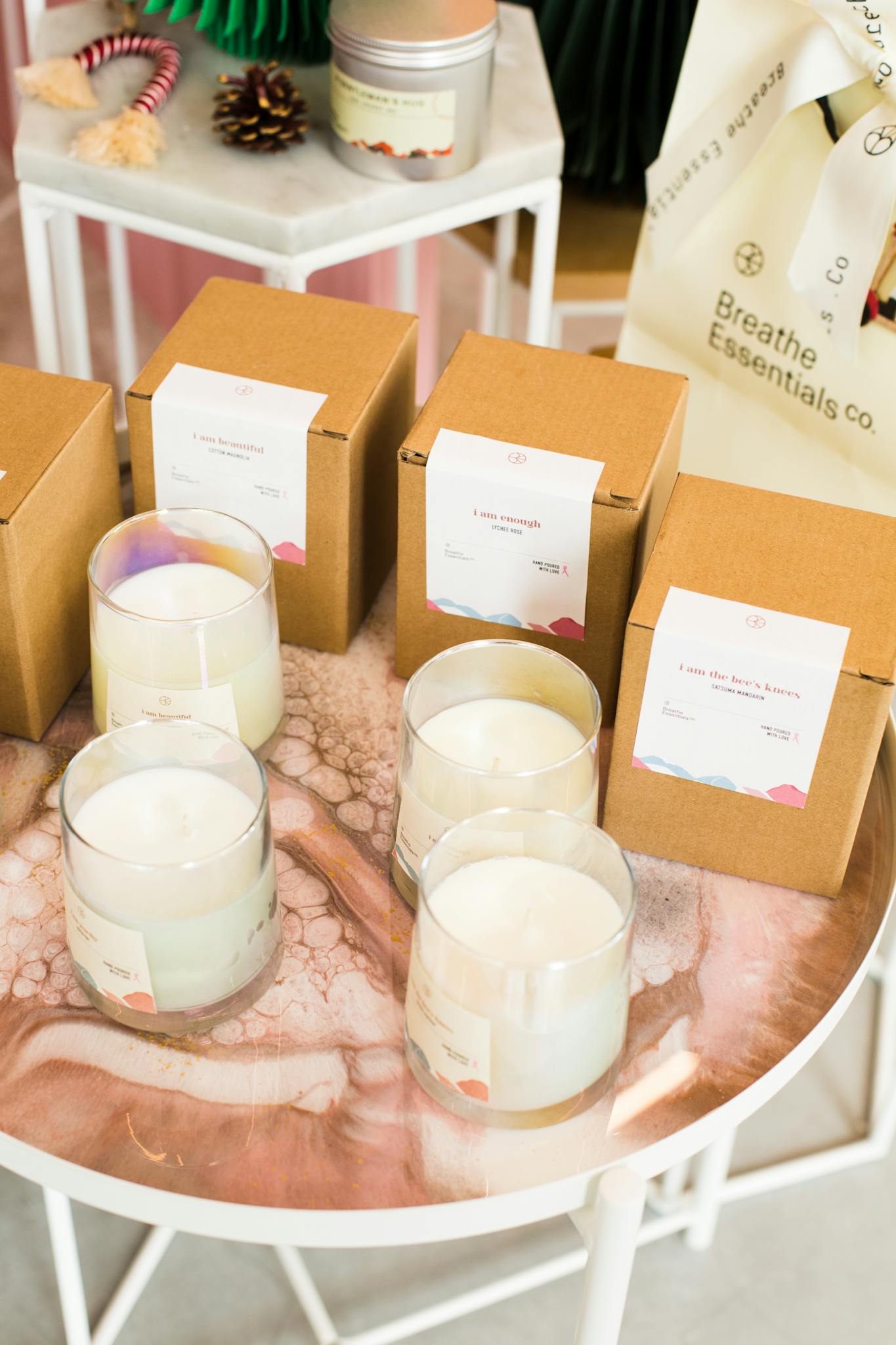 A high-angle shot of artisanal scented candles and packaging on a stylish table.
